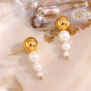Detailed macro view of 18K gold plated earrings with three gradient pearls and golden stud