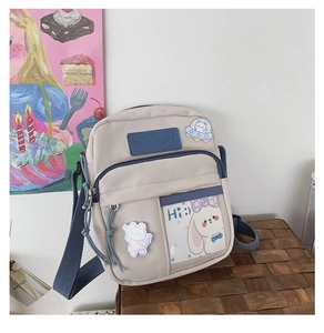 Détail du sac bandoulière en toile avec poche transparente, broderie et sangle réglable