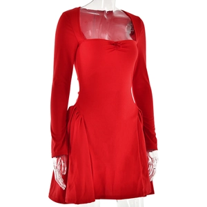 Détail de la robe rouge à col carré avec petit nœud et taille froncée sur fond blanc