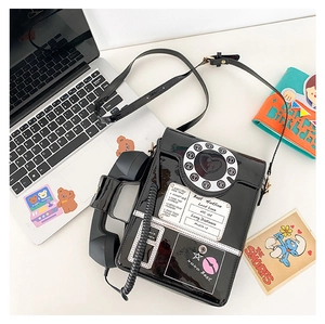 Detail of creative vintage black telephone crossbody bag with white stitching and pink accents
