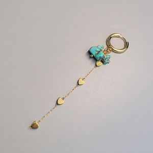 Detail of gold drop earrings featuring turquoise stones and four heart charms on long chains