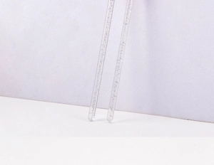 Detailed macro view of two crystal eyelash brush handles with glitter glitter flakes