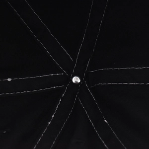 Macro detail of inner six-panel stitching and metal rivet on black cotton baseball cap