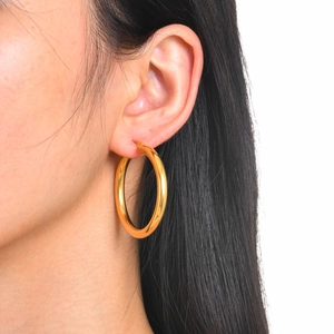 Minimalist 18k gold plated stainless steel thick hoop earrings worn by a model