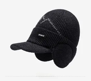 Detail view of winter black knit hat with fleece lining, protective earflaps and brim
