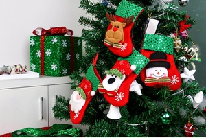 Detail of hanging sequined Christmas stockings with Santa and snowman on tree branch