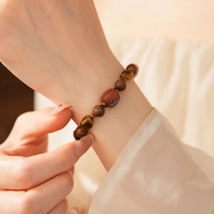 Gros plan des perles d'œil de tigre et d'agate sur un bracelet en bois d'agar