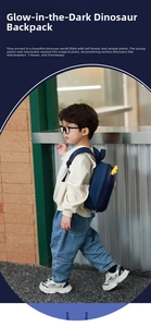 Detail of navy dinosaur backpack with yellow 3D fins on toddler boy walking outdoors