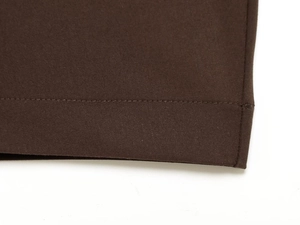 Detailed close-up of the stitching and brown fabric texture on these stylish trousers
