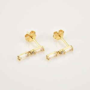 Macro shot of 925 sterling silver gold earrings with three rectangular white zircons