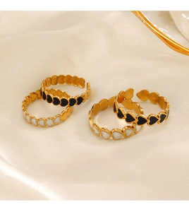 Macro detail of 18K gold plated heart rings with black and white enamel drip oil finish