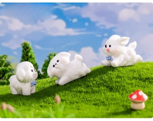 Miniature white resin puppy with blue bowtie on moss landscape garden decoration
