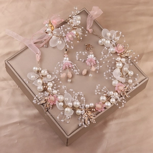 Detailansicht des Brautschmuck-Sets mit Perlen und rosa Blumen auf Seidenhintergrund