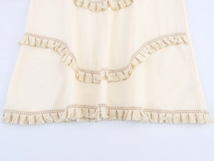 Detail view of beige bohemian skirt with wavy stitching and layered fringe tassels