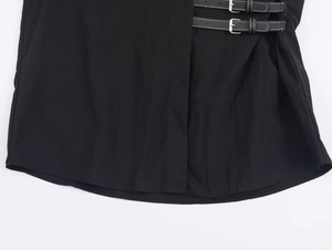 Detail of poplin shirt featuring black straps with contrast white stitching and metal buckles