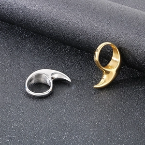 Detail of polished gold and silver crescent moon rings on a dark textured background