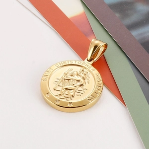 Detailed macro view of a gold Saint Christopher coin pendant with embossed religious relief