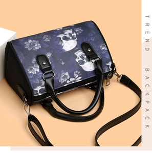 Macro detail of gothic skull and floral print on a barrel shaped crossbody handbag