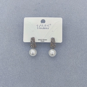 Detail view of pearl earrings with S925 silver posts and pavé rhinestones for women
