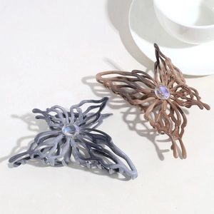 Detail of grey and brown gradient butterfly hair claws with shimmering iridescent center gems