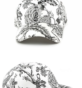 Detail of white baseball cap with black floral Toile de Jouy sketch print and curved brim