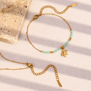 Detail of 18K gold-plated bracelet featuring green natural stones and a leaf charm