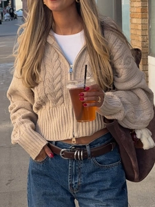 Dettaglio della trama a trecce e zip sul cardigan corto beige da donna