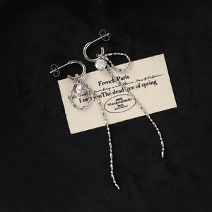 Macro detail of silver tassel earrings with sparkling cubic zirconia on vintage label