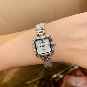 Close-up of elegant square silver watch with pearl dial and diamond markers for women