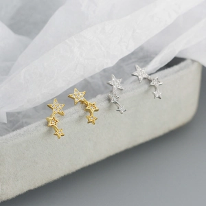 Detail of star-shaped 925 sterling silver studs with cubic zirconia on gray velvet