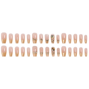 French tip press-on nails in nude and gold glitter with rhinestones, long coffin shape