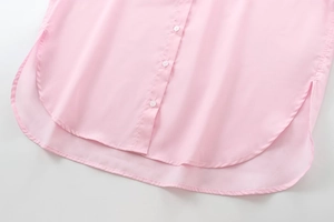 Detail of pink cotton shirt hem with white buttons and smooth side slit stitching