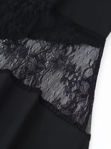 Detailed view of black floral lace stitching and smooth fabric texture on the dress