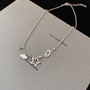Macro view of silver star necklace with heart pendant on minimalist book cover