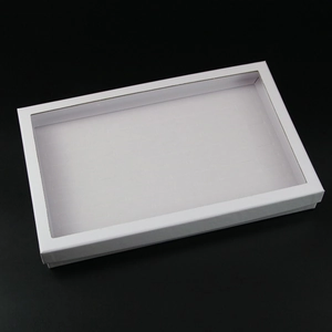 Detailed top view of white ring box with transparent window and storage slots
