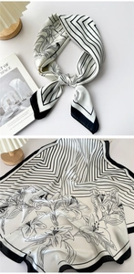 Detail of silk-feel scarf featuring black and white lily floral prints and geometric lines