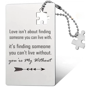 Close-up of silver stainless steel wallet card with puzzle piece and engraved message