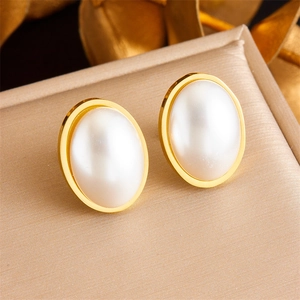 Elegant gold plated stainless steel oval pearl earrings displayed on a jewelry box