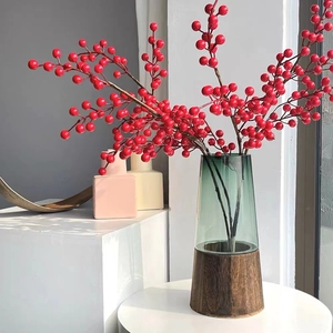 Green gradient glass vase with wooden base and decorative red berry branches