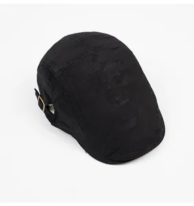 Top view of black mesh flat cap showing breathable texture and brass metal buckle