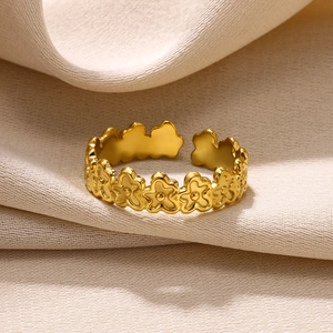 Detailed macro view of a gold-finish open ring featuring a delicate five-petal floral design