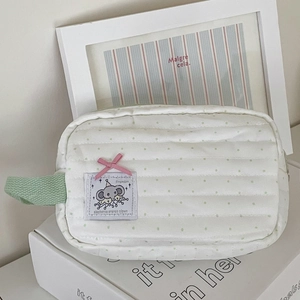 Detail of mint green polka dot elephant makeup bag with green handle and quilted fabric