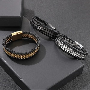 Detailed view of woven black leather bracelets with magnetic clasps in gold, silver and black