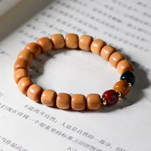 Macro detail of sandalwood beaded bracelet with tri-color accent beads and metal spacers