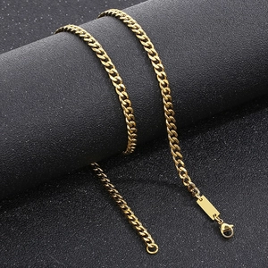 Gold plated hip-hop Cuban link necklace with rectangular pendant on a black pillar display