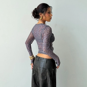Dettaglio del top in mesh viola leopardato e pantaloni neri in ecopelle