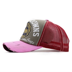 Detail of vintage washed mesh cap with embroidery patch and distressed pink brim