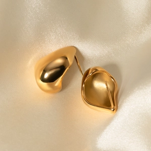 Macro shot of 18k gold plated stainless steel teardrop earrings on champagne silk