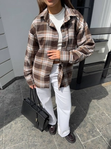 Detail of loose fit brown plaid flannel shirt jacket with button-down design for women