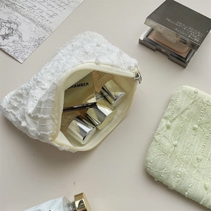 Detailed view of textured chiffon flower makeup bags with fringe and metal zippers